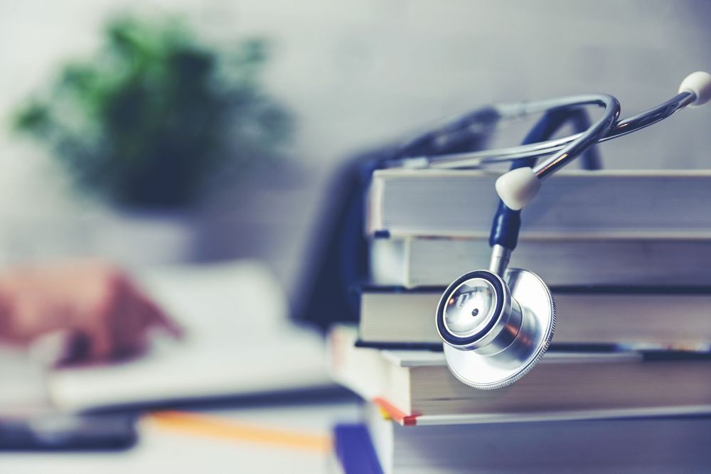 Stethoscope resting on medical textbooks