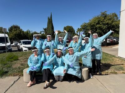 Students in light blue uniforms celebrating outdoors